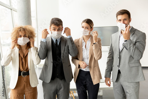 Portrait of young business people taking off their protective face masks