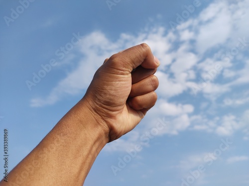 Original picture of fist on sky background