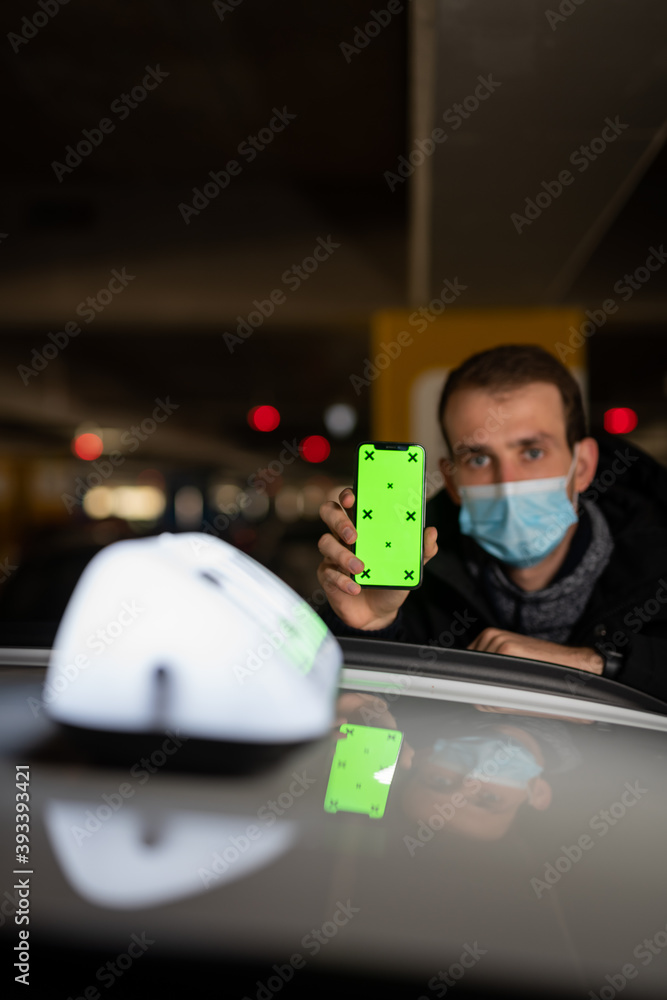 Young taxi driver showing something at his phone