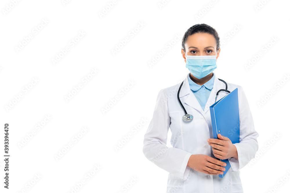 African american doctor in white coat and medical mask holding paper folder isolated on white African american doctor in white coat and medical mask holding paper folder isolated on white