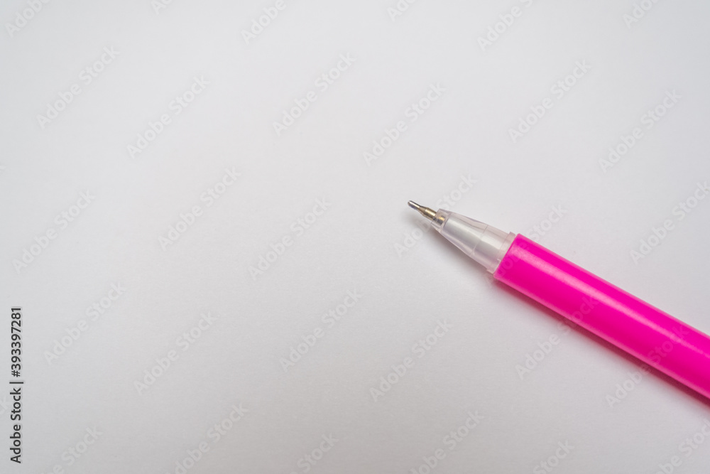 Top view of a pink pen on a white paper background. Simple background with place for text