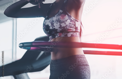 Sporty woman is exercising with Hula hoop in fitness gym for healthy lifestyle concept. photo