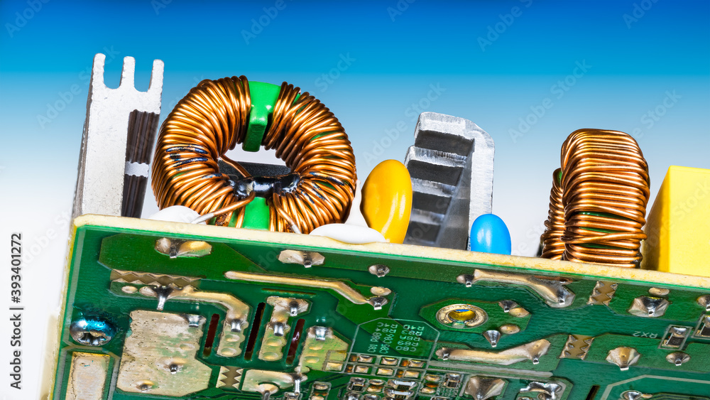 Toroidal electronic inductors soldered on circuit board detail. Copper ...