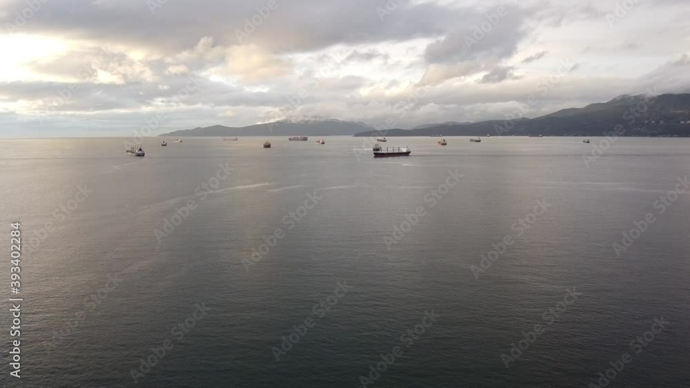 Fly over the bay in Vancouver with cargo ships waiting near the port Fly over the bay in Vancouver with cargo ships waiting near the port