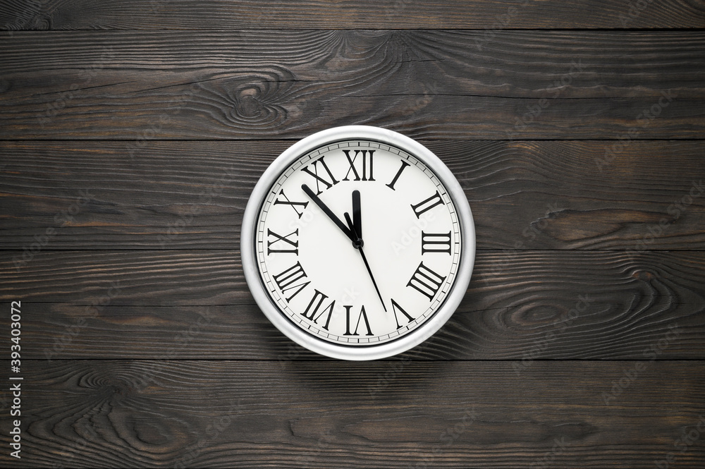 Wall clock at textured wooden background. Copy space, minimal style