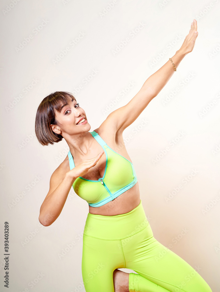 Happy woman posing giving positive energy with green yoga scales and gym outfit. Happy woman posing giving positive energy with green yoga scales and gym outfit.