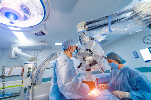 Doctor performs minimally-invasive surgeon using a robotic device. Minimal invasive neurosurgical innovation. Medical robot surgery with endoscopy.