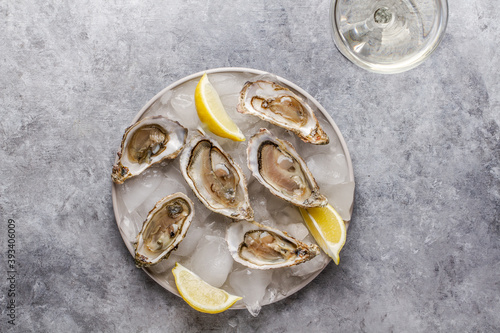 Fresh raw oysters on ice with lemon and glass of champagne