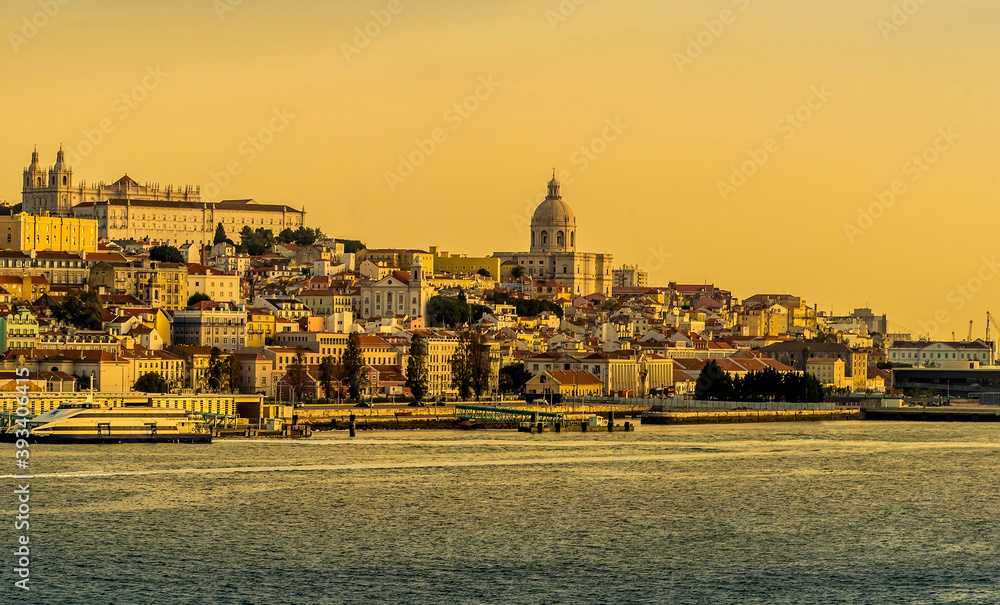 The old quarter of Lisbon viewed from the river Tagus in the golden early morning light at sunrise in Autumn