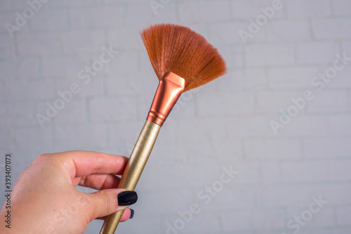 Close up view of woman’s hand holding make up brush