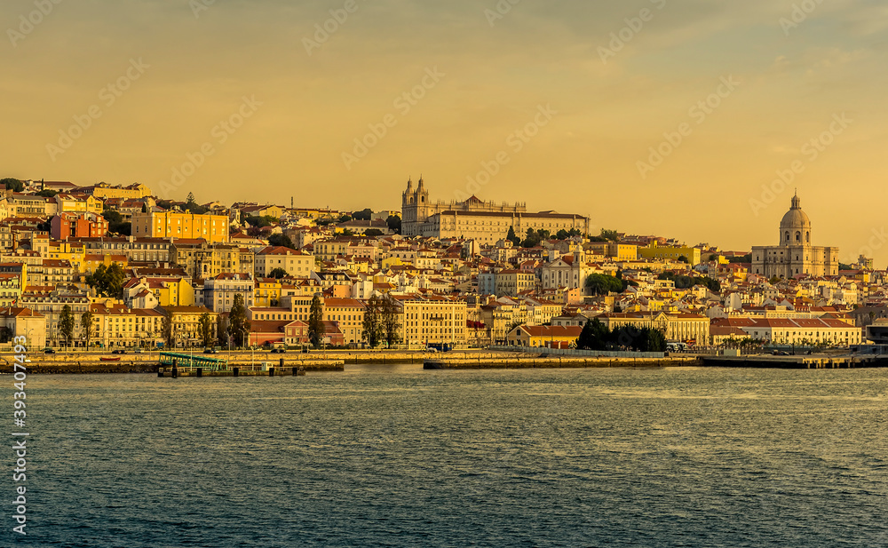Fototapeta premium The old quarter of Lisbon, Portugal viewed from the river Tagus in the early morning light at sunrise in Autumn