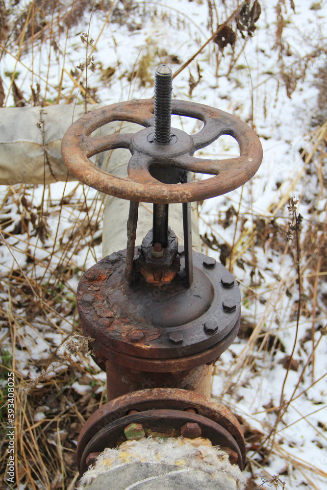 Old damaged and rusty iron oil pipe valve wheel. Metal, pipeline and mechanic concept. An old iron valve on a gas pipe. A valve to cover the pipe with a round handle Old damaged and rusty iron oil pipe valve wheel. Metal, pipeline and mechanic concept. An old iron valve on a gas pipe. A valve to cover the pipe with a round handle