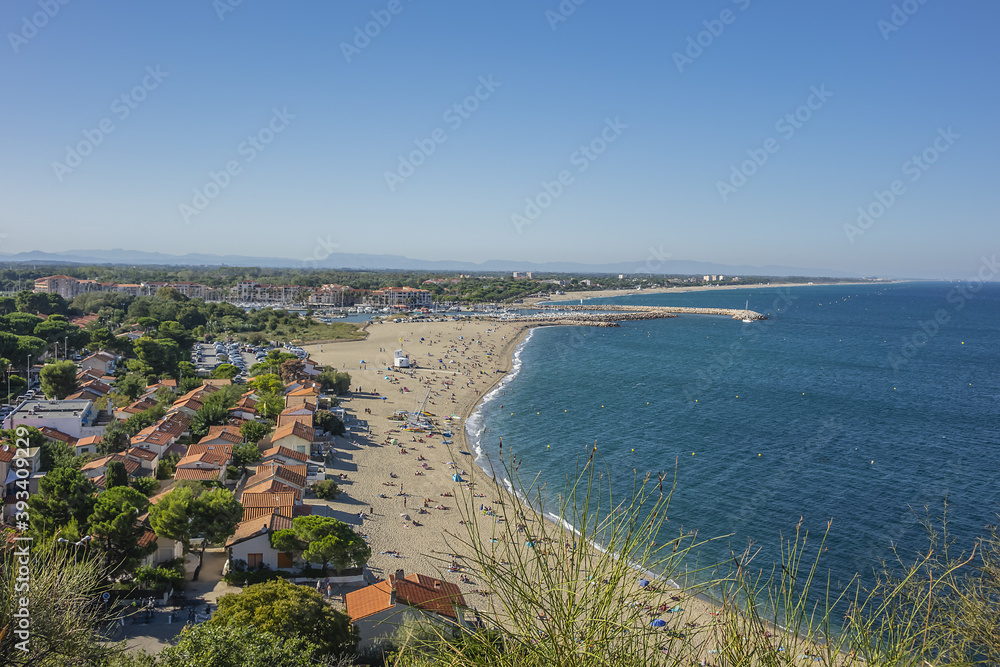 Obraz premium Sandy Mediterranean beach Le Racou in Argeles sur Mer with its old fishermens houses and the harbor in background, Roussillon, Pyrenees Orientales, France.