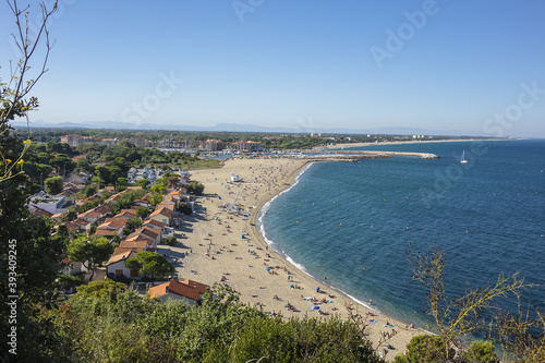 Sandy Mediterranean beach Le Racou in Argeles sur Mer with its old fishermens houses and the harbor in background, Roussillon, Pyrenees Orientales, France. photo