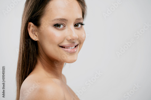 Beautiful woman smiling shows healthy teeth, clean fresh young skin. Natural makeup, full lips and bright eyes. Young model female brunette