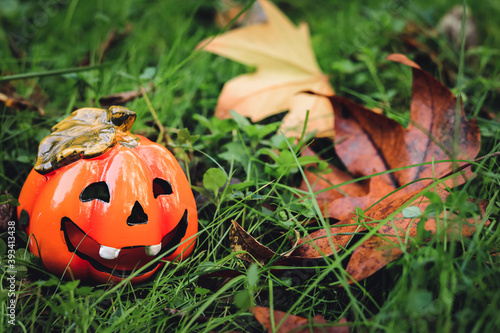 Wallpaper Mural Pumpkin shaped ceramic candlestick on green grass with yellow leaves Torontodigital.ca