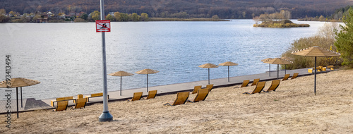 View of the deserted beach with umbrella and deckchairs. Landscape: sea and wave on coast with relaxation view.