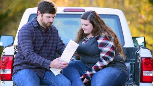 Couple, with pick-up making plans for traveling with map coffee and picnic basket