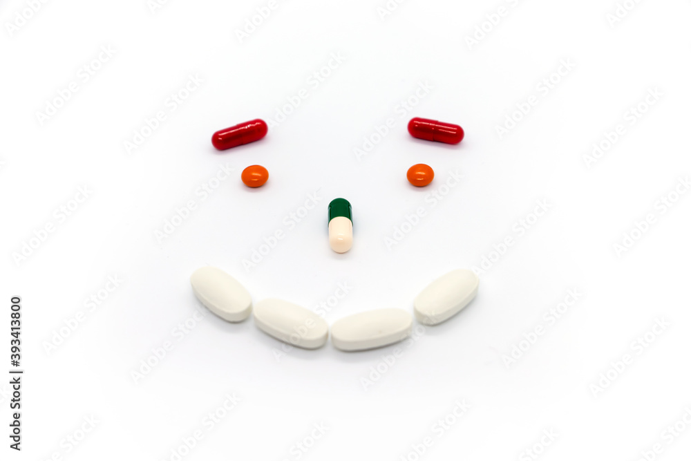 Smiling face made from multicolored pills on white background. Smiling face made from multicolored pills on white background.