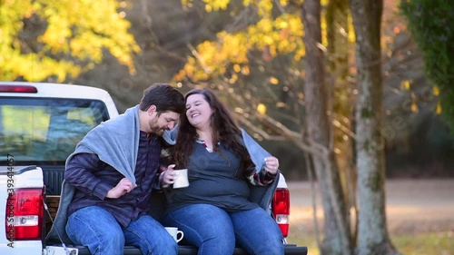 Couple, with pick-up making plans for traveling with map coffee and picnic basket
