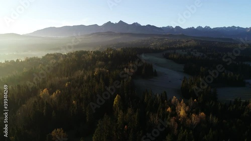 Mountain aerial. Epic mountain landscape with morning fot and soft light of sunrise. Beautiful aerial alpine view. photo