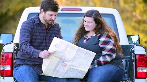 Couple, with pick-up making plans for traveling with map coffee and picnic basket