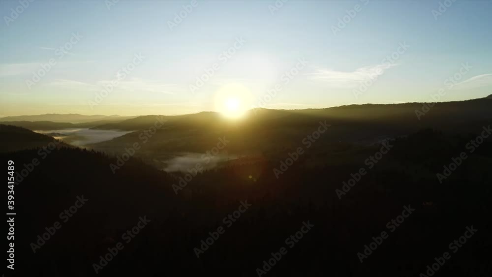 Mountains aerial landscape during sunrise. Epic sunrise in a mountain landscape. Valley covered with morning fog, beautiful sun rays.