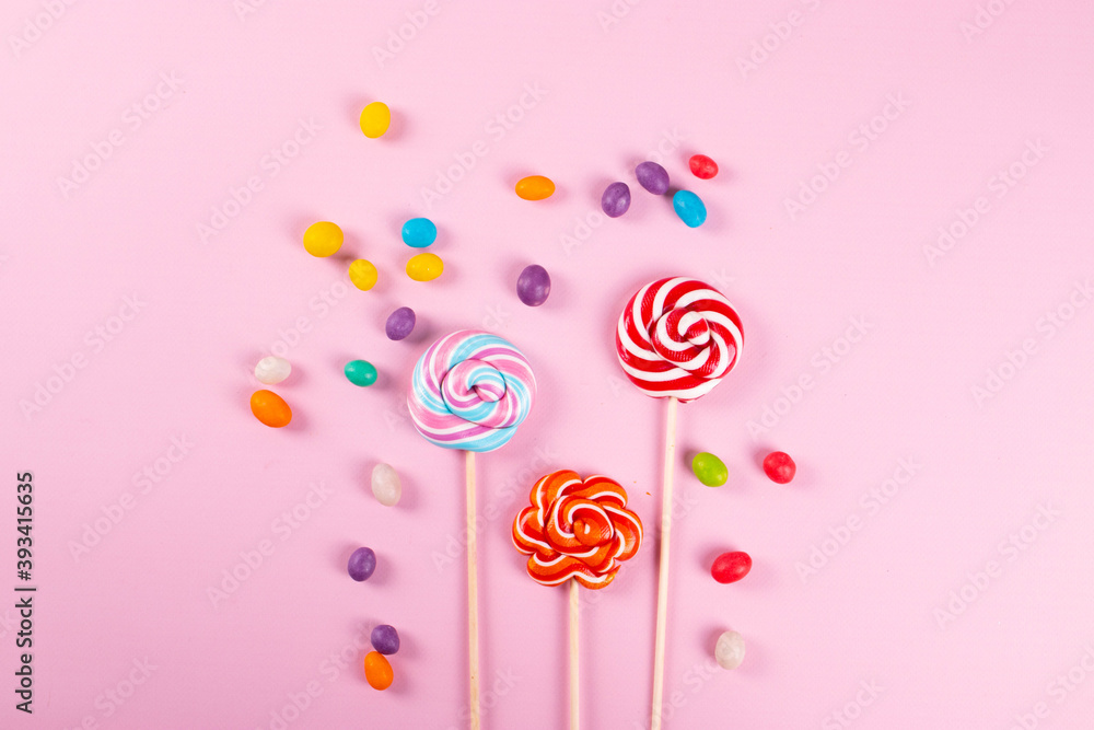 yummy sweet colour round lollipops on the pink background. minimalism style. yummy sweet colour round lollipops on the pink background. minimalism style.
