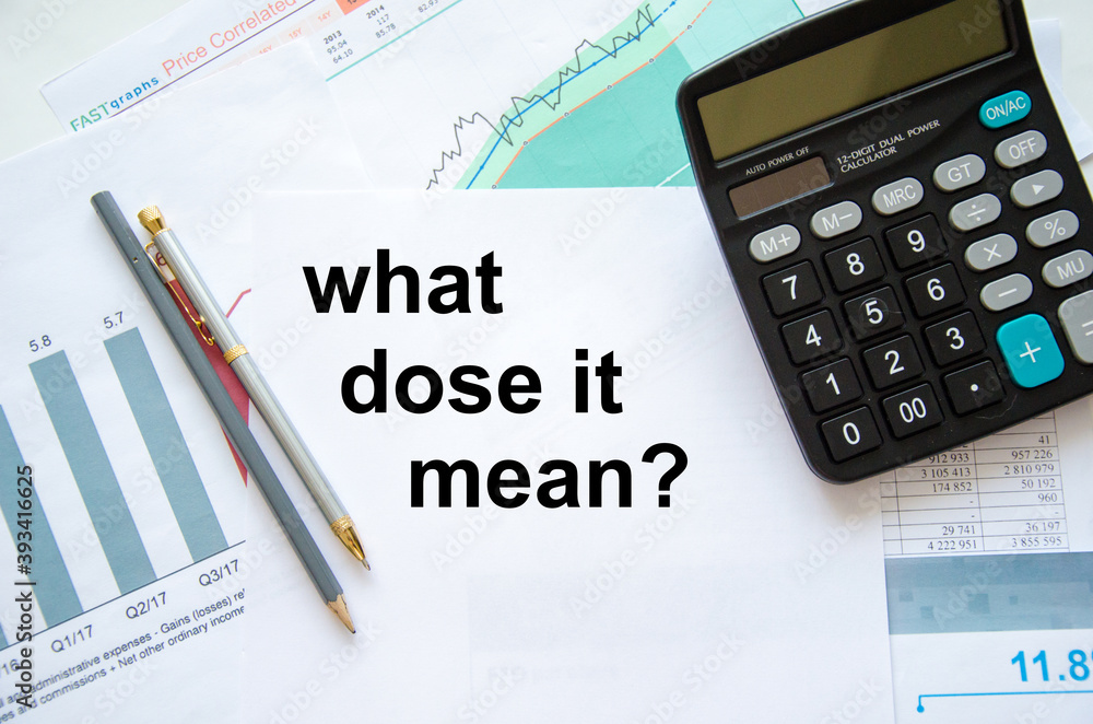 the text what this mean is written on a white sheet of paper which lies on the financial statements and next to a calculator and a pen the text what this mean is written on a white sheet of paper which lies on the financial statements and next to a calculator and a pen