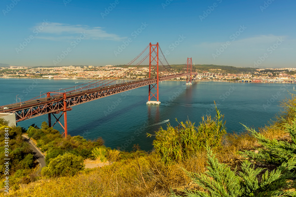 The suspension bridge over the Tagus river named after the 25th April revolution, viewed from the Almada district of Lisbon, Portugal
