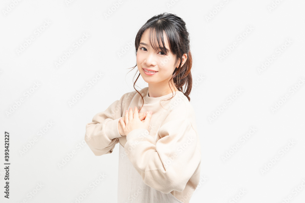 胸に手を当てる若い女性 胸に手を当てる若い女性