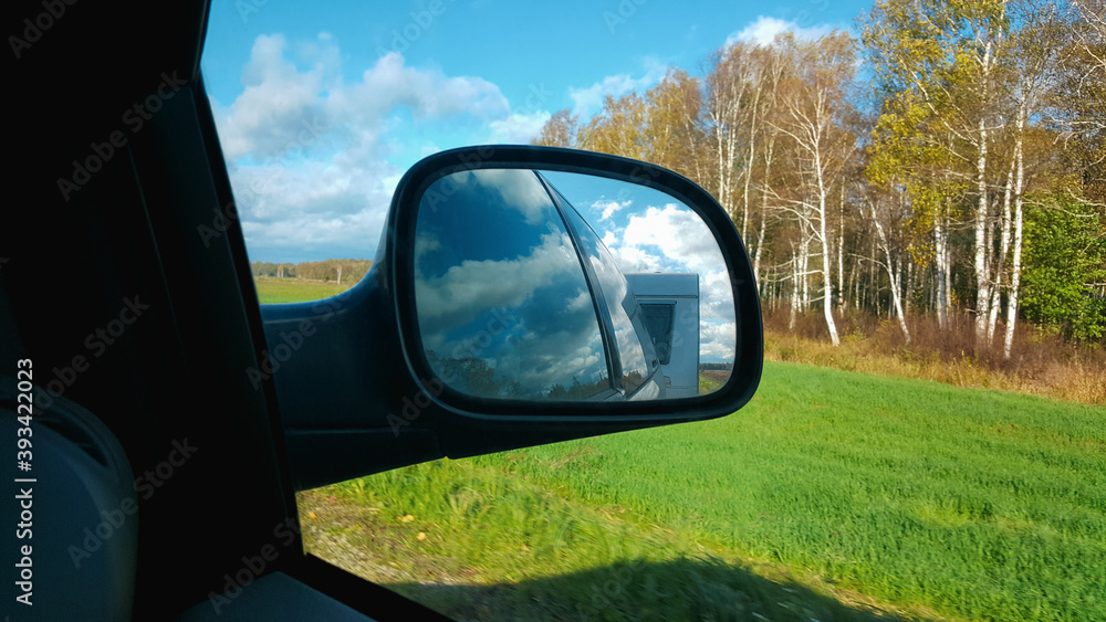 Camper van reflection in the sideview mirror of a car. Life on the