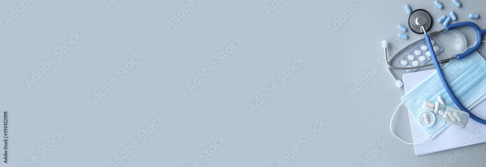 Fototapeta premium Health care and virus protection concept, medical stethoscope or phonendoscope, white pills on gray background.