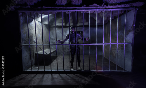 Jail or prison cell. Man in prison man behind bars concept. Old dirty grunge prison miniature. Dark prison interior creative decoration. Selective focus © zef art