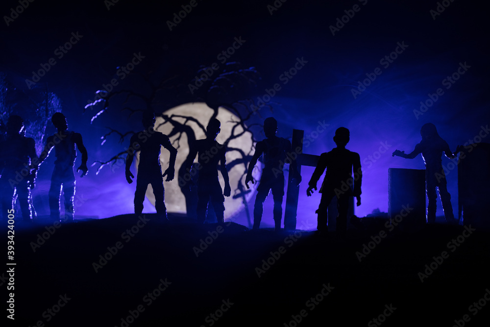 Scary view of zombies at cemetery dead tree, moon, church and spooky cloudy sky with fog, Horror Halloween concept with glowing pumpkin. Selective focus Scary view of zombies at cemetery dead tree, moon, church and spooky cloudy sky with fog, Horror Halloween concept with glowing pumpkin. Selective focus