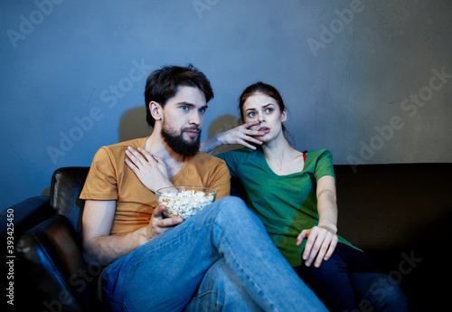 evening tv watching and a married couple with popcorn in a plate © SHOTPRIME STUDIO