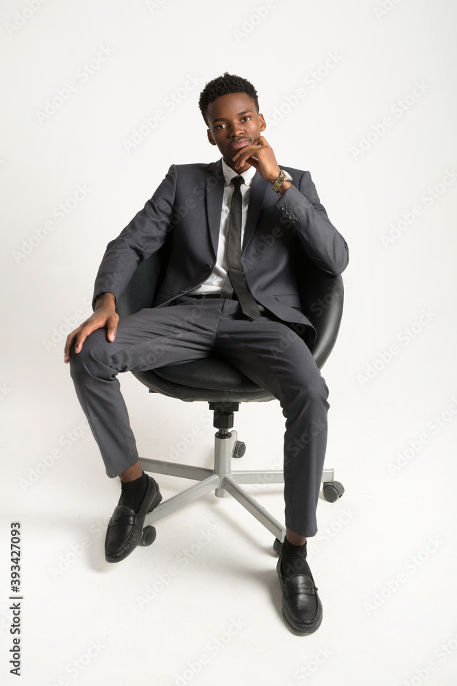 handsome young african man in suit on white background in armchair handsome young african man in suit on white background in armchair