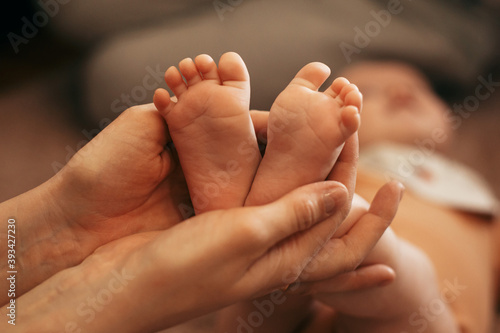 the mother holds the baby's legs in her hands