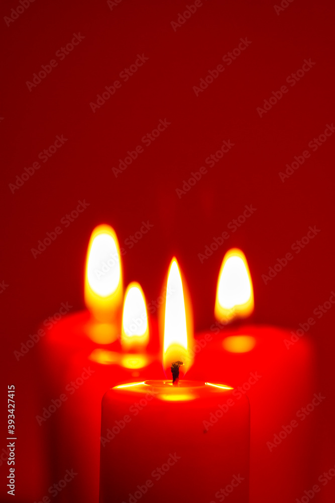 Four burning candles on snow dark red background Four burning candles on snow dark red background