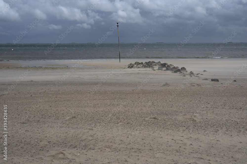 Fliegender Sand am Strand mit Kardinalzeichen