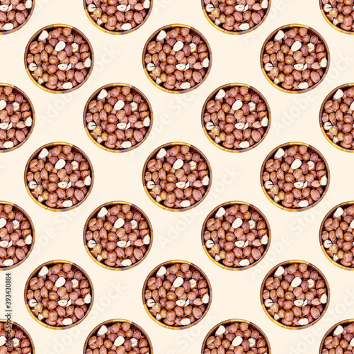 Top view flat lay hazelnut nuts in a round wooden bowl repeat seamless pattern on light background.