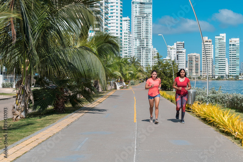 Women running through a park. Concept of fitness
