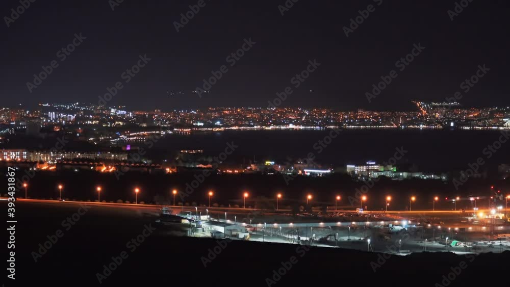 View of illuminated Gelendzhik city with bay at night, reflected in water of sea bay. View of illuminated Gelendzhik city with bay at night, reflected in water of sea bay.