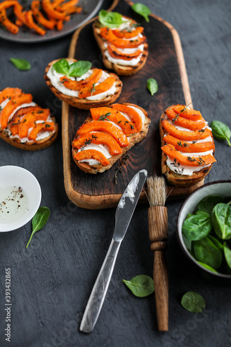 Sandwiches with cream cheese and baked pumpkin slices. Autumn recipes for snacks. View from above.
