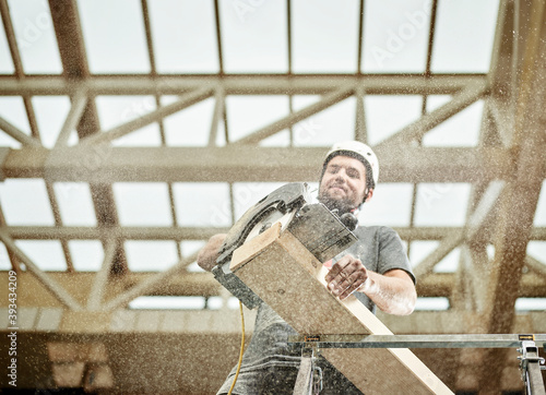 Austria, worker sawing wood photo