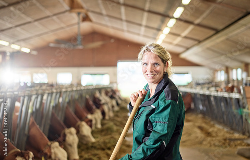 Portrait of smiling female farmer in stable on a farm photo