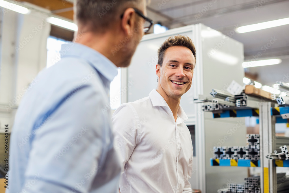 Portrait of smiling businessman with colleague in factory Portrait of smiling businessman with colleague in factory