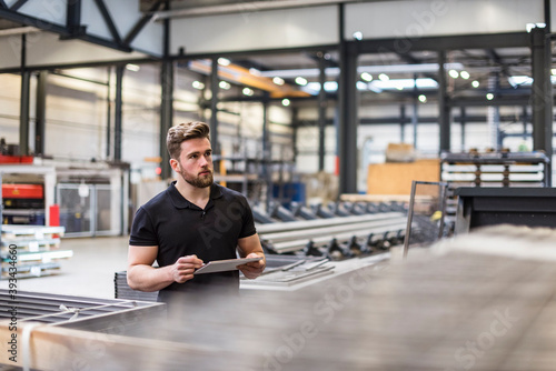 Man using tablet on factory shop floor