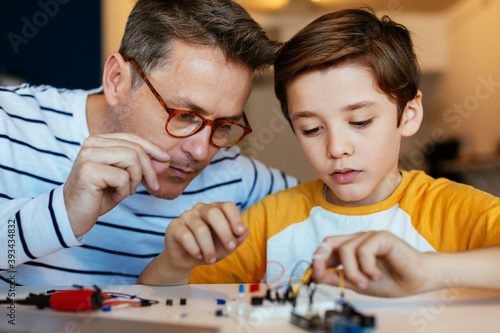 Father and son assembling an electronic construction kit photo