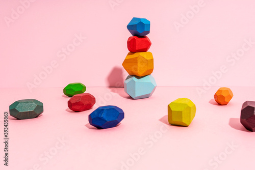 Stack of multi colored wooden block against pink background photo